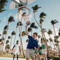 Ados qui jouent au Volley sur la plage avec palmiers
