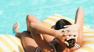 Femme sur un transat en bord de piscine