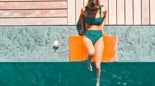 Femme assise sur le bord d'une piscine