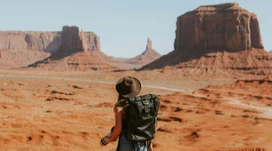 Femme avec sac à dos devant Monument Valley