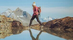 Femme en randonnée devant une montagne et un lac