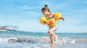 Petite fille avec une bouée à la plage