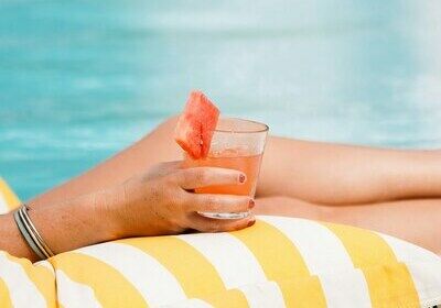 Cocktail dans la main d'une femme à la piscine