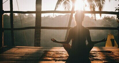 Femme faisant du yoga au coucher du soleil