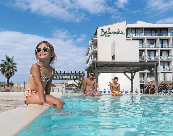 Petite fille assise au bord d'une piscine