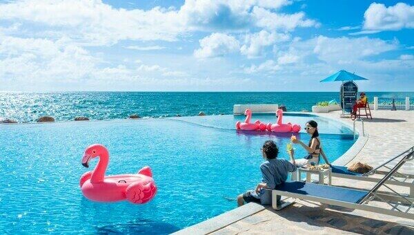Piscine à débordement avec bouées flamant rose