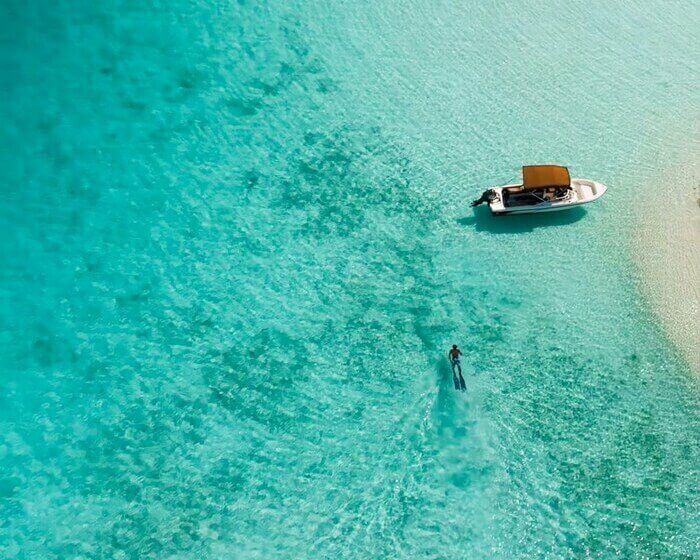 Homme qui nage dans l'eau turquoise avec palmes