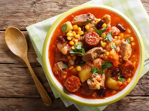Assiette de katchupa avec maïs, légumes et viande dans une sauce rouge
