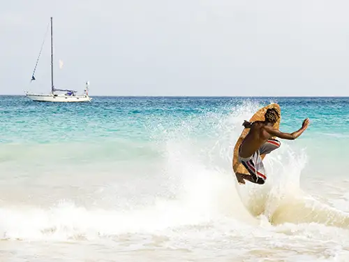 Homme avec planche en bois sur une vague