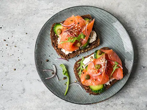 Assiette avec tartines de pain, concombre et saumon