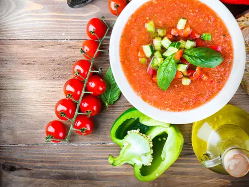 Bol de gaspacho avec tomates en grappe et poivron vert