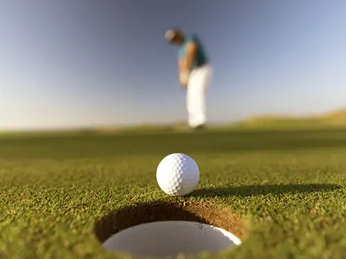 Balle de golf et golfeur en arrière plan