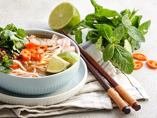 Bol avec bouillon, nouilles et légumes