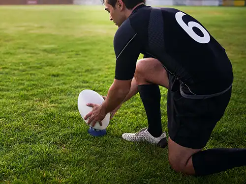Ballon de rugby et joueur sur un terrain