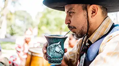 Homme avec un chapeau qui boit à la paille