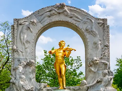 Statue or de Mozart avec une arche sculptée derrière