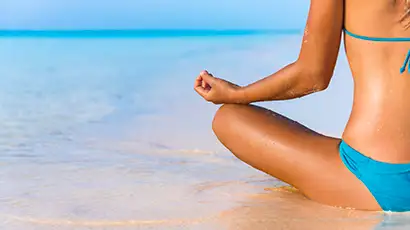 Femme assise dans l'eau en bord de mer