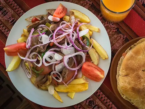 Assiette avec frites, viande, tomates crues et oignon