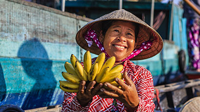 femme avec régime de bananes