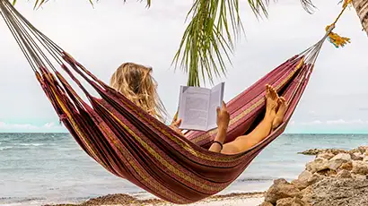 Femme qui  lit dans un hamac