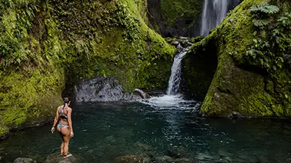 Femme en maillot devant une cascade