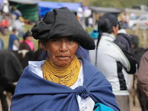 Femme avec collier de peres jaunes et tissu noir sur a tête