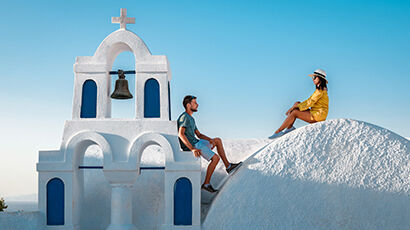 Couple sur les maisons blanches et bleues à Santorin