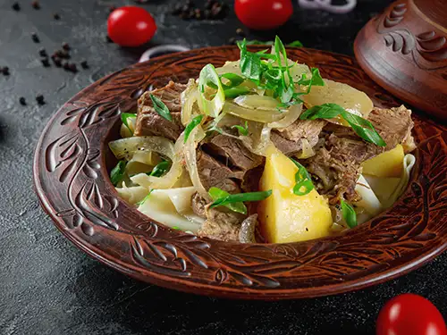 Assiette avec viande, oignons et pommes de terre