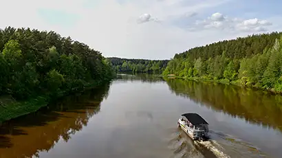 Petit bateau sur un fleuve entouré de forêt
