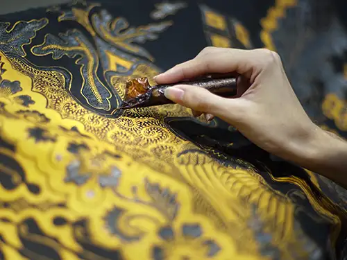 Main d'une femme sur un tissu jaune et noir