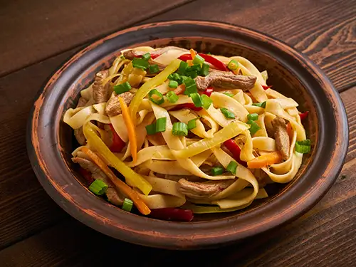 Assiette de tsuivan avec des pâtes, carottes, pommes de terre et mouton