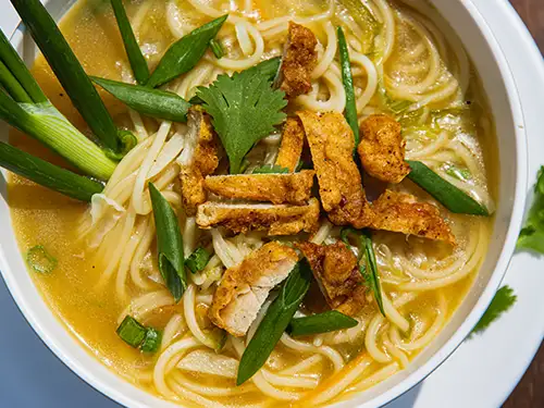 Soupe avec nouilles, herbes et poulet pané