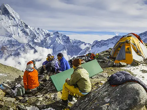 Alpinistes assis devant les sommets enneigés