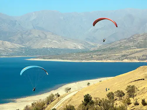 2 parapentes dans les montagnes au-dessus d'un lac
