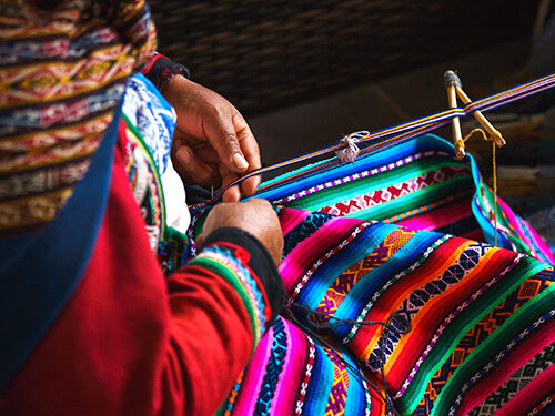 Femme qui tisse un tissu coloré