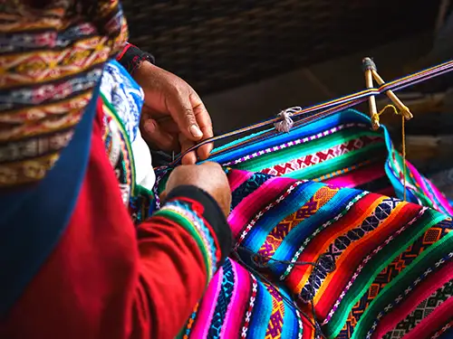 Femme qui tisse un tissu coloré
