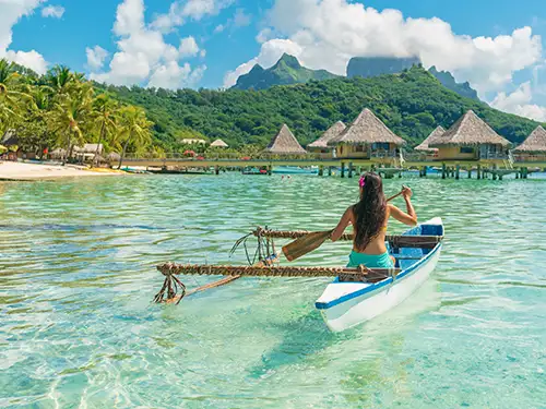 Femme en pirogue sur lagon turquoise