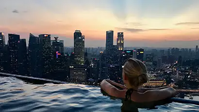 Femme dans une piscine à débordement avec vue sur les gratte-ciels