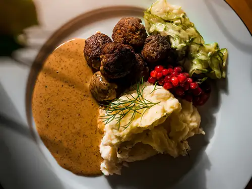 Assiette avec purée, boulettes et baies rouges