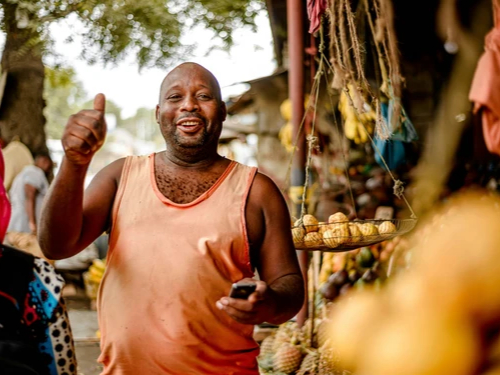 Vendeur qui sourit sur un marché en Tanzanie