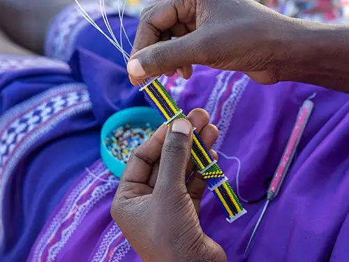 Mains de femme qui fait un bracelet en perles