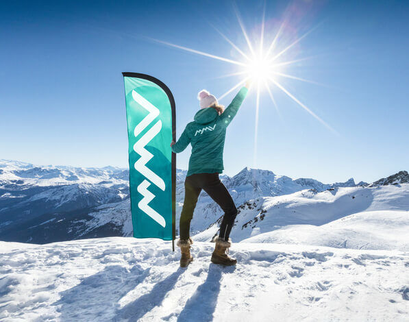 Club MMV dans les Alpes Femme au sommet d'une montagne enneigées