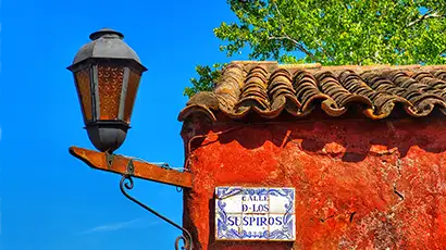 Coin d'une maison à la façade rouge et pancarte de nom de rue